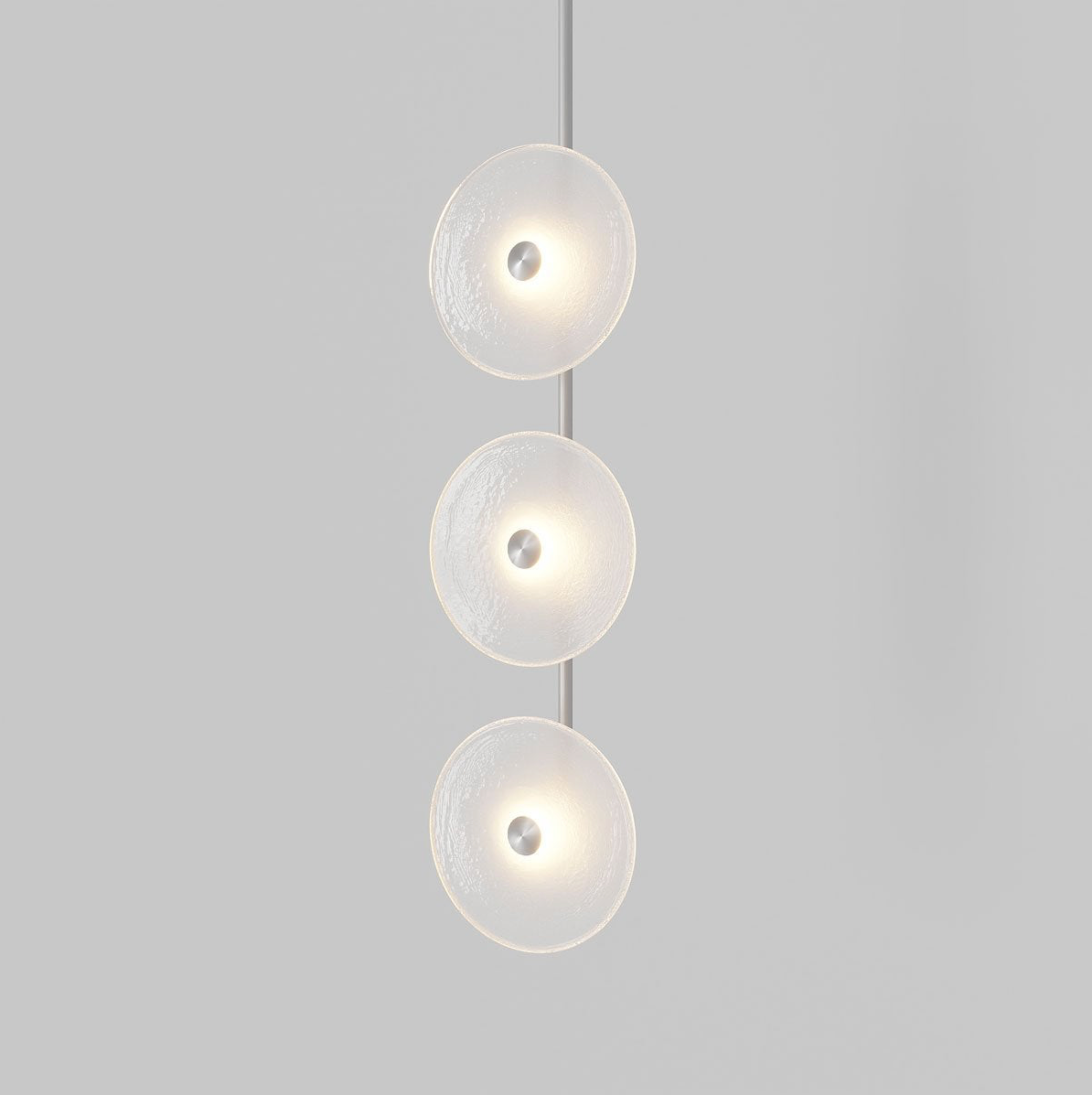 Modern pendant light with three circular glass shades on a gray background