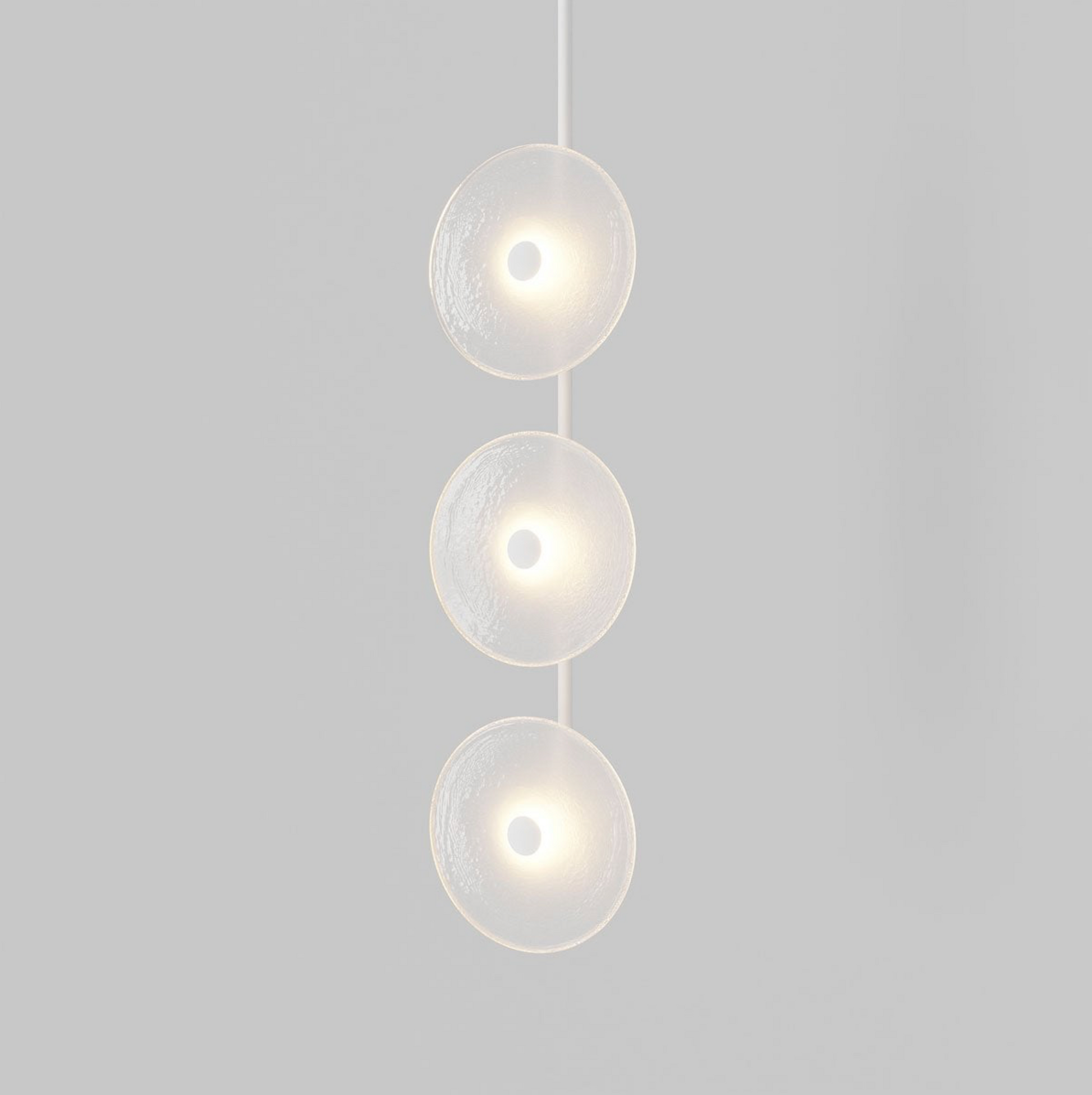 Modern pendant light with three spherical glass shades on a grey background