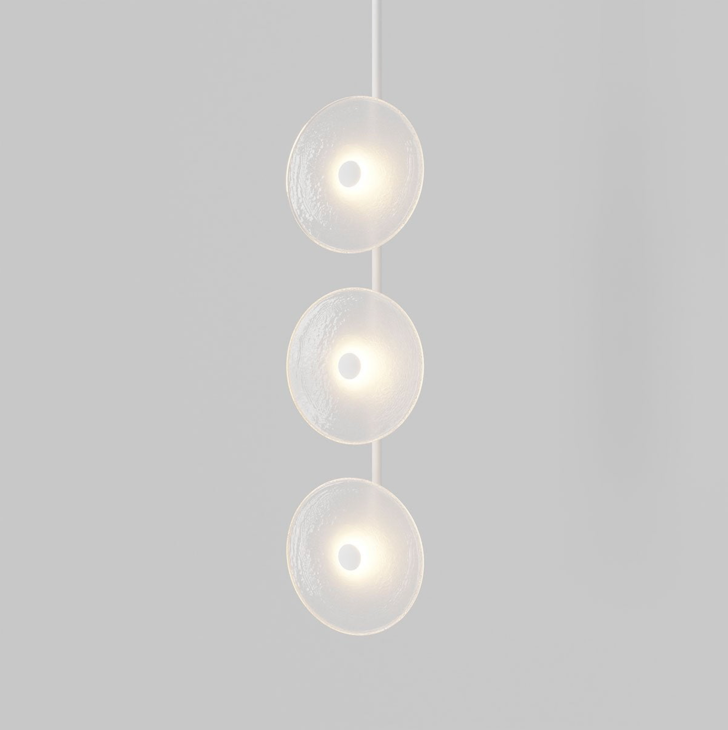 Modern pendant light with three spherical glass shades on a grey background