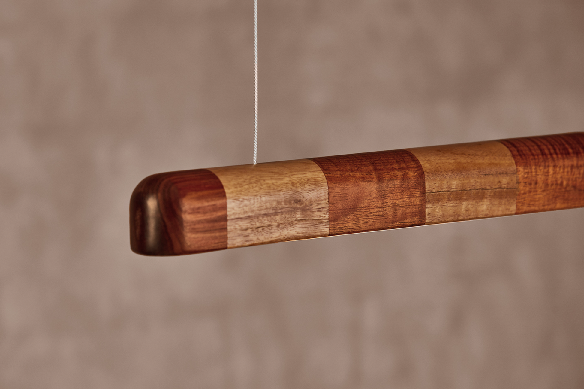 Close-up of Kich pendant light end cap in Red Gum and Vic Ash hardwood timber with cable suspension