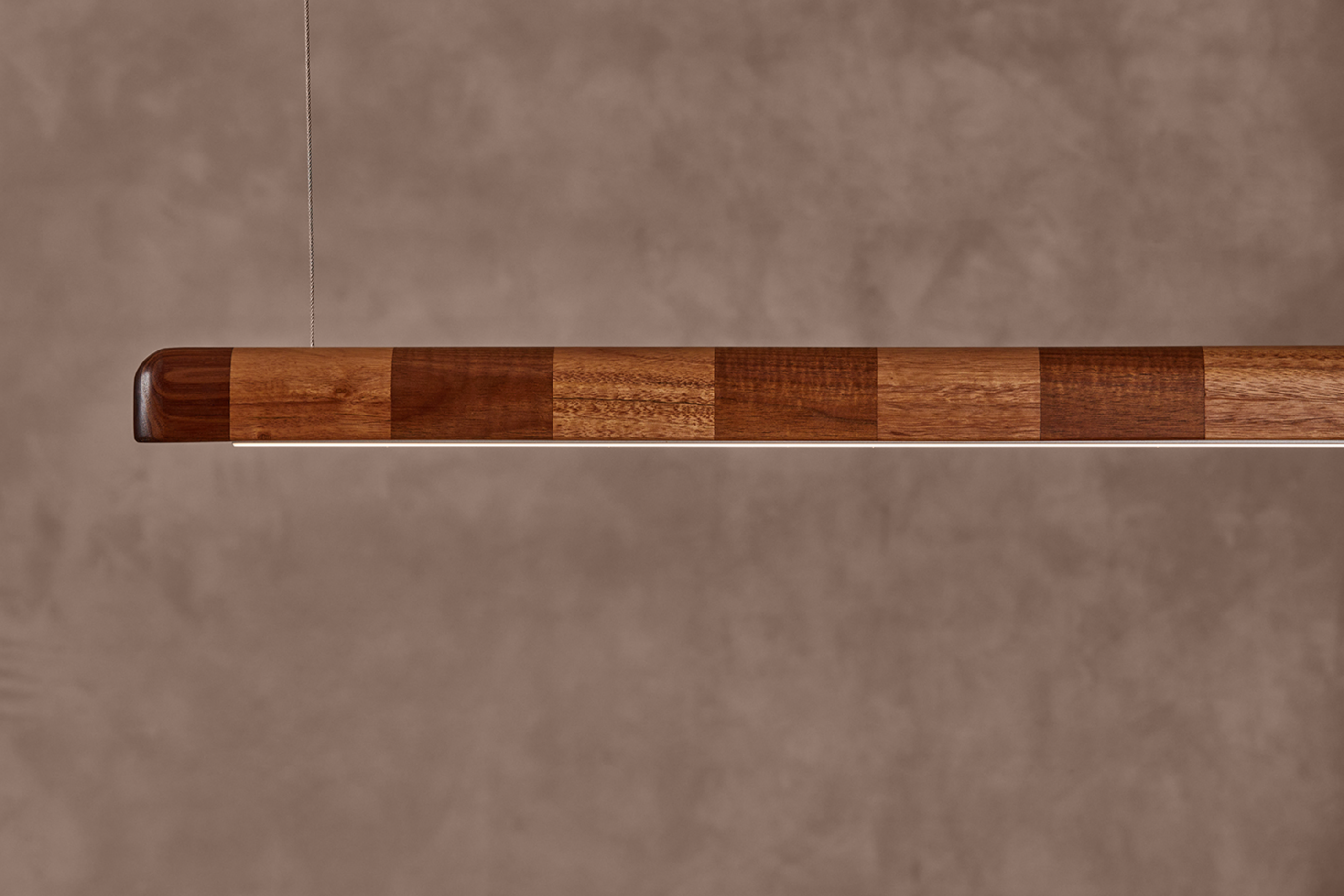 Kich pendant light full length view showing striped hardwood timber body with LED strip and cable suspension