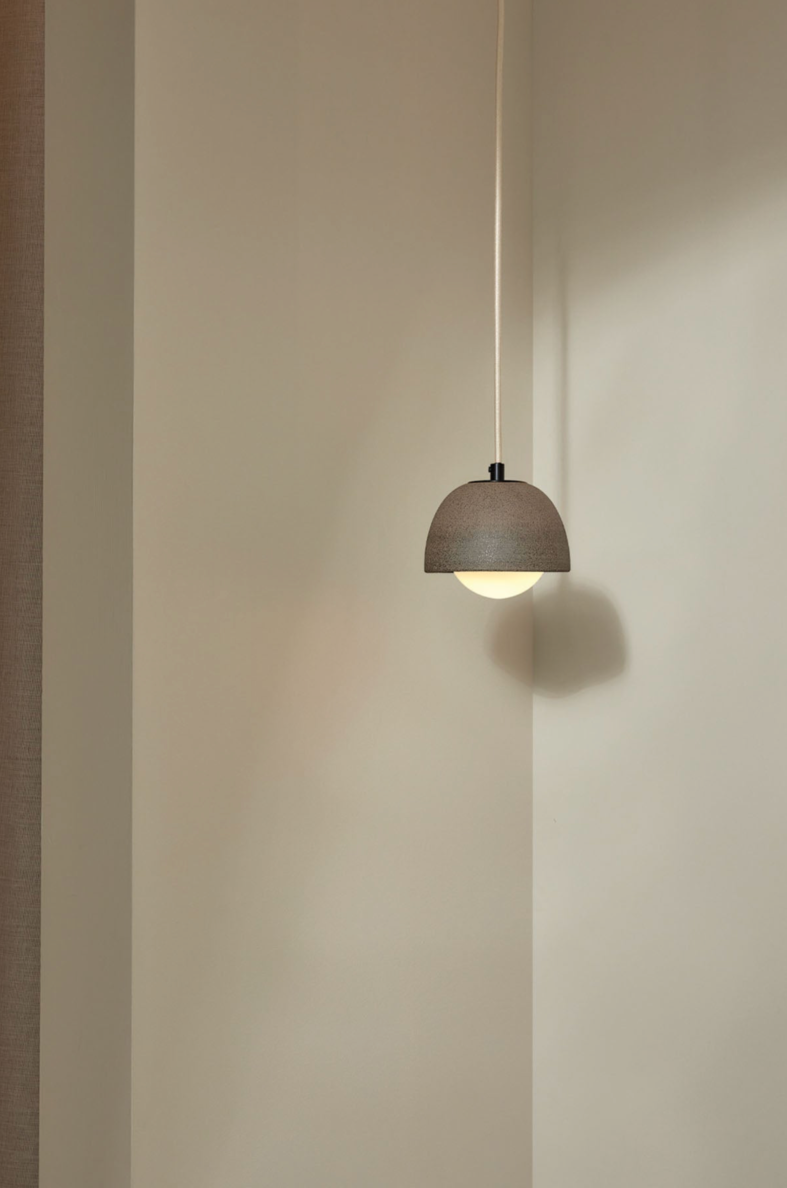 Pendant light fixture hanging against a plain wall