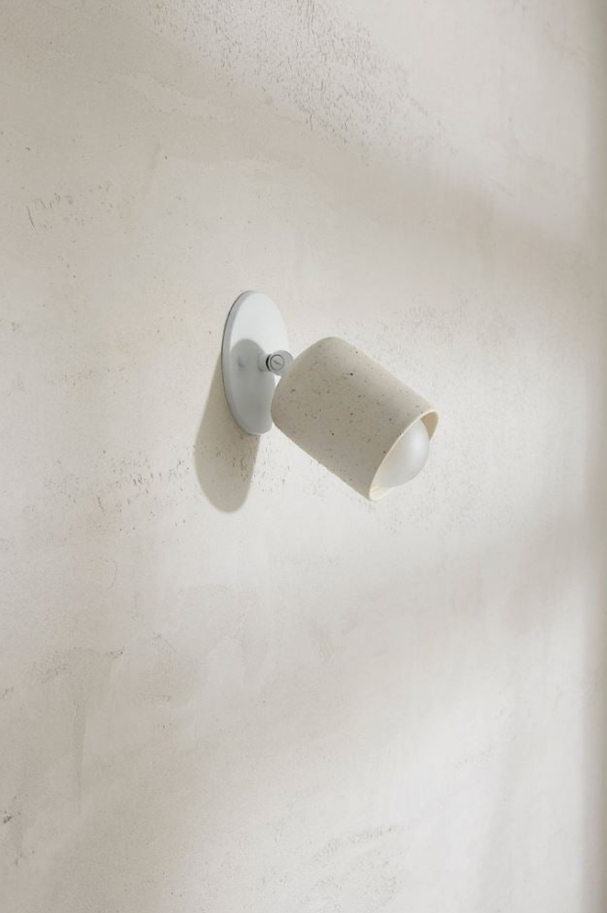 Ceramic wall light fixture on a textured white wall