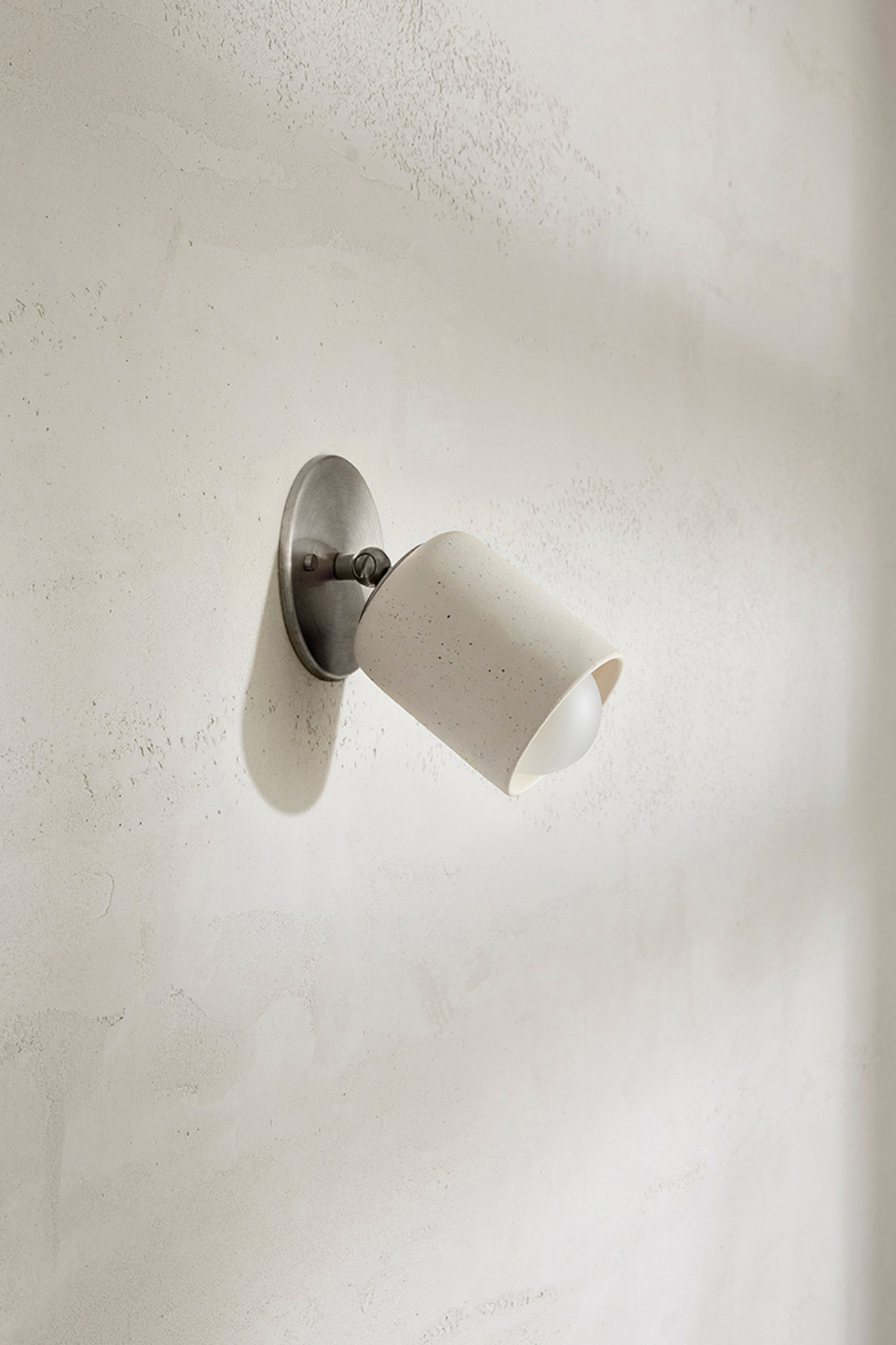 Wall-mounted light fixture on a textured white wall