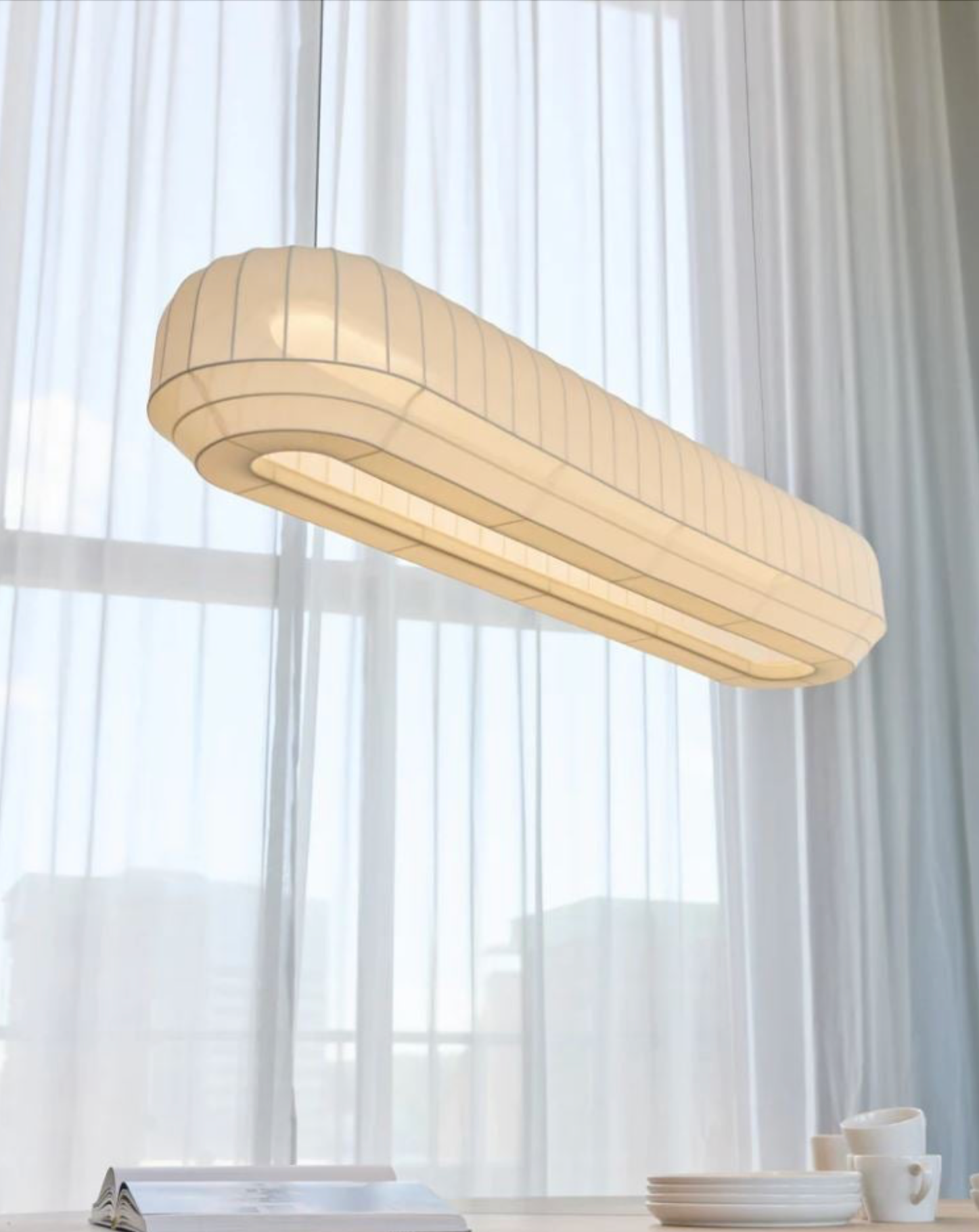 Linear pendant light fixture in a room with white curtains