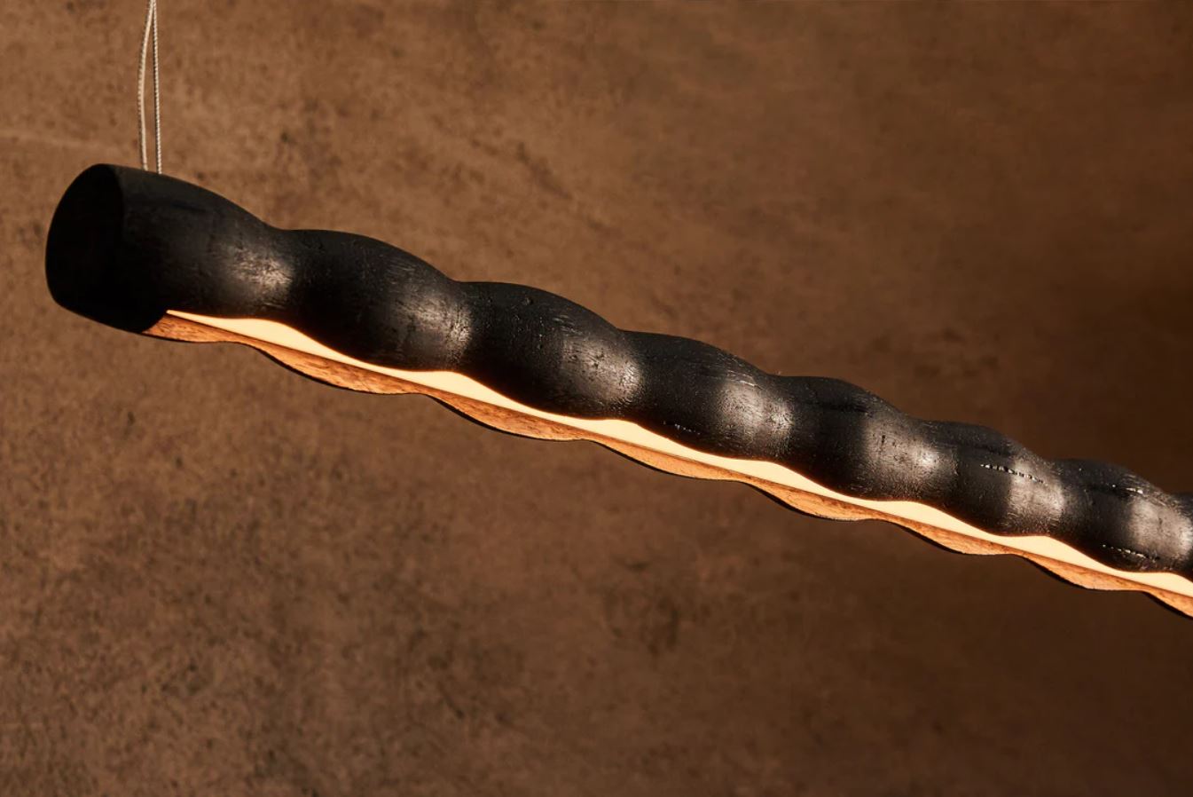 Wood linear pendant light on a textured brown background