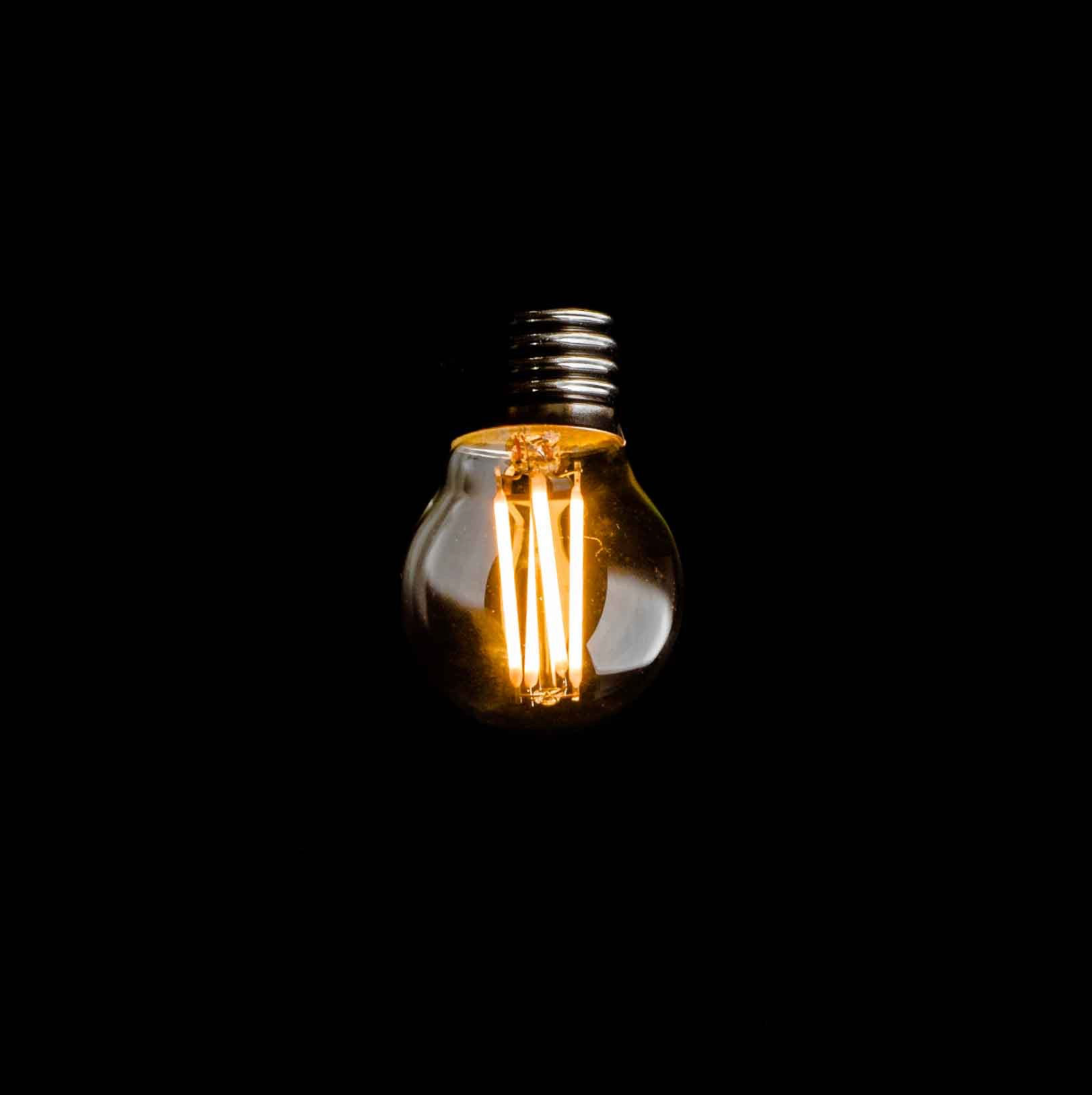 Light bulb filament glowing against a black background