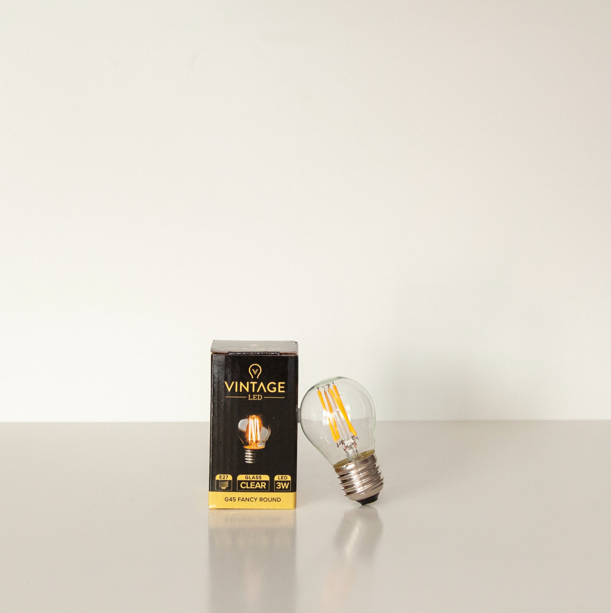 Vintage LED light bulb and its packaging on a white background