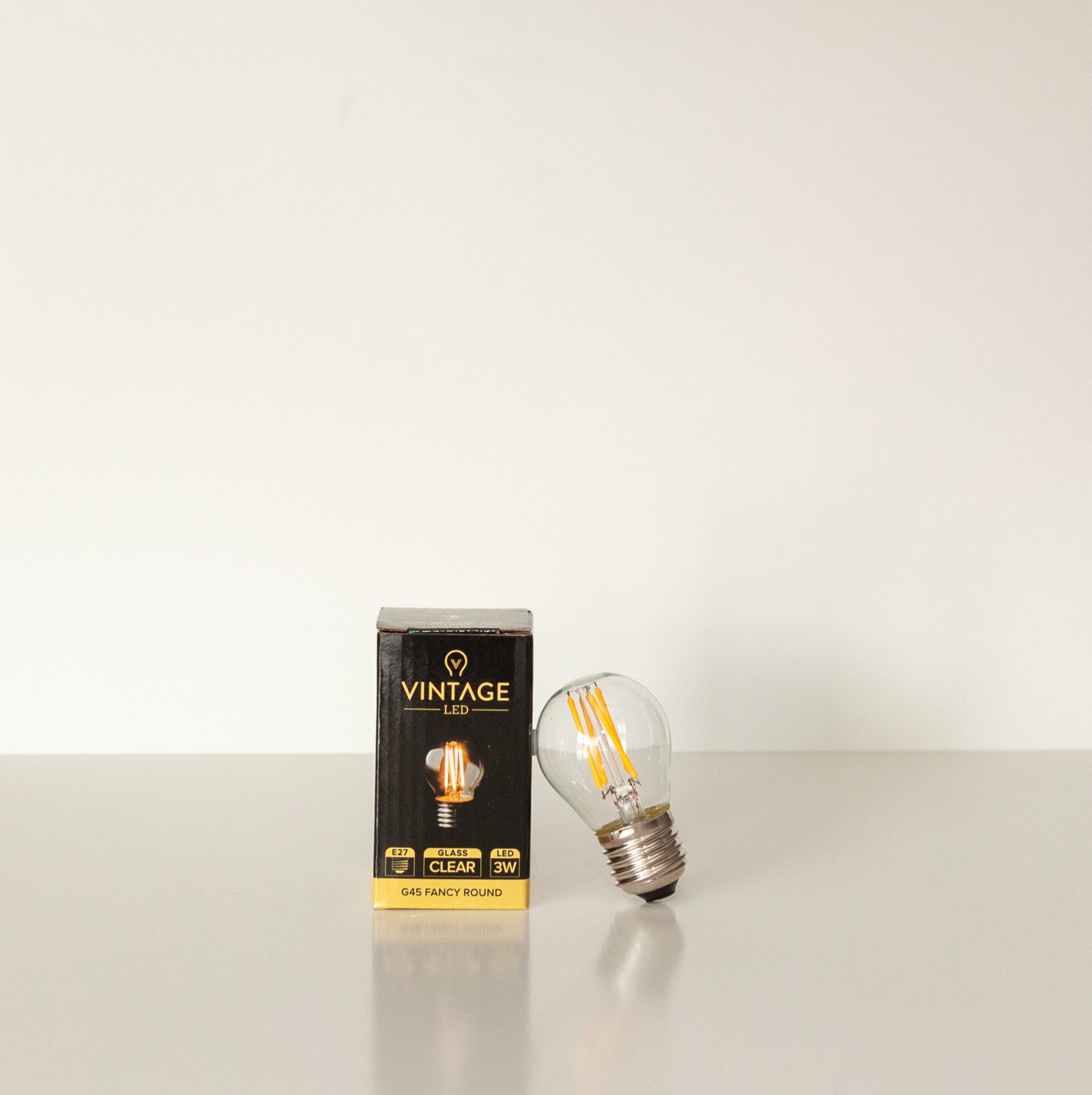 Vintage LED light bulb and its packaging on a white background