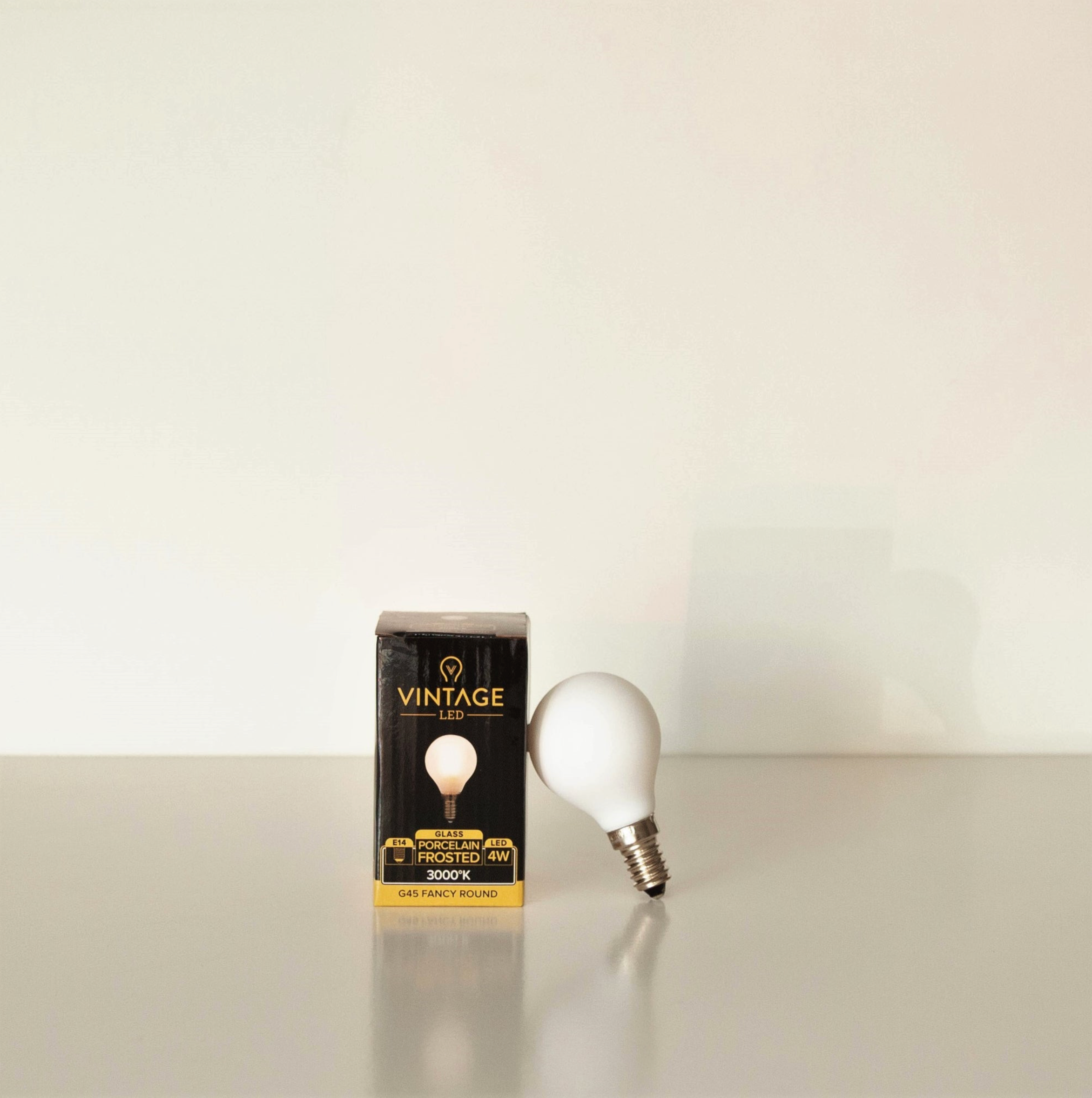 Vintage LED light bulb packaging with a white bulb on a beige background