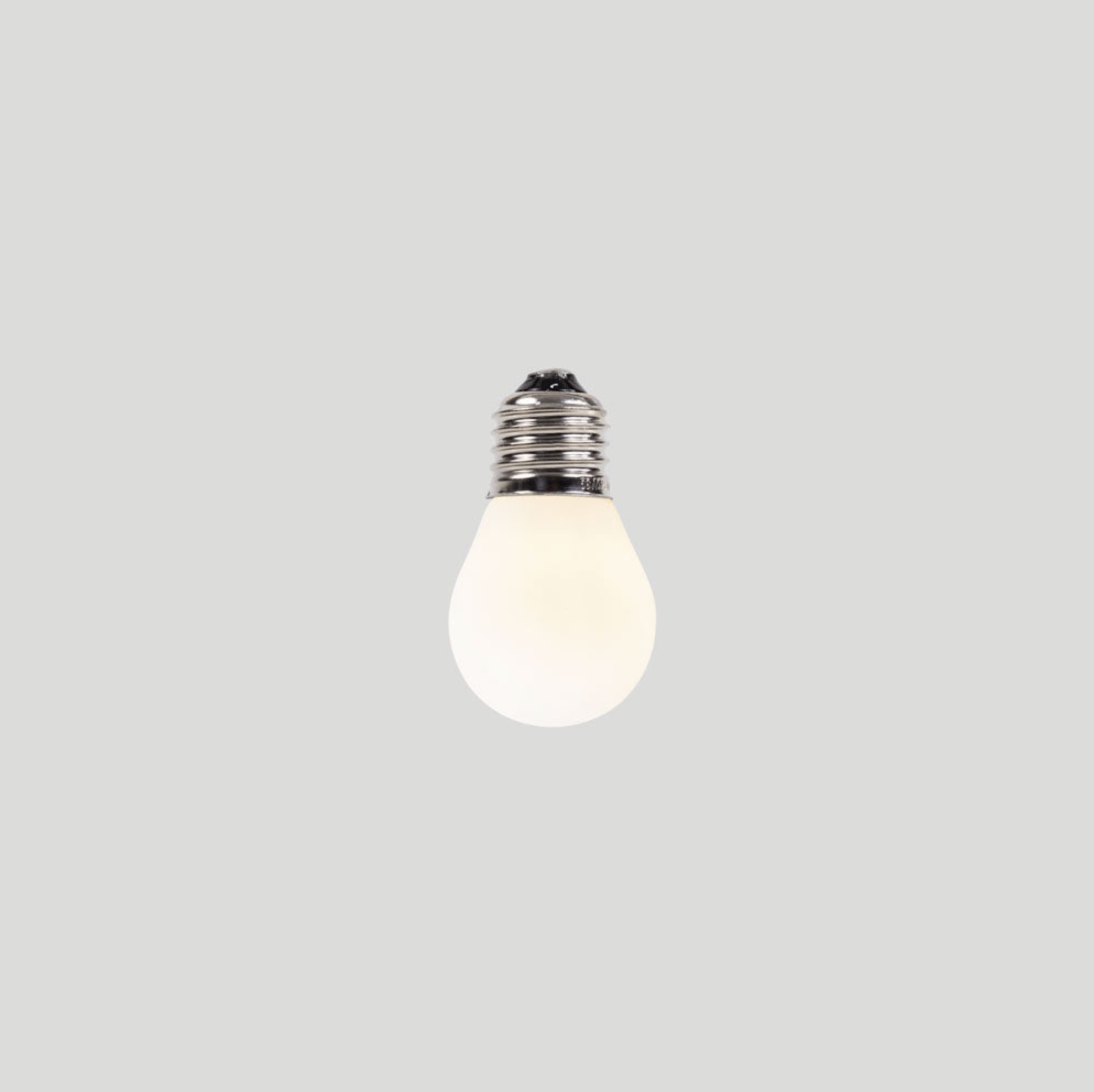White frosted light bulb on a grey background