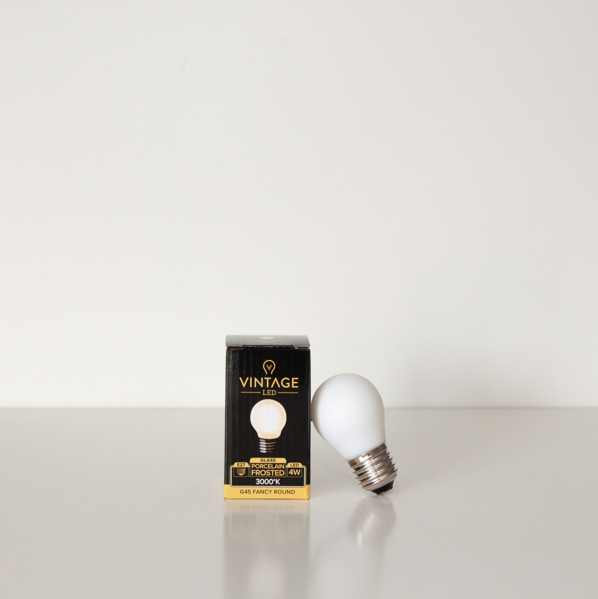 Vintage LED light bulb and its packaging on a white background