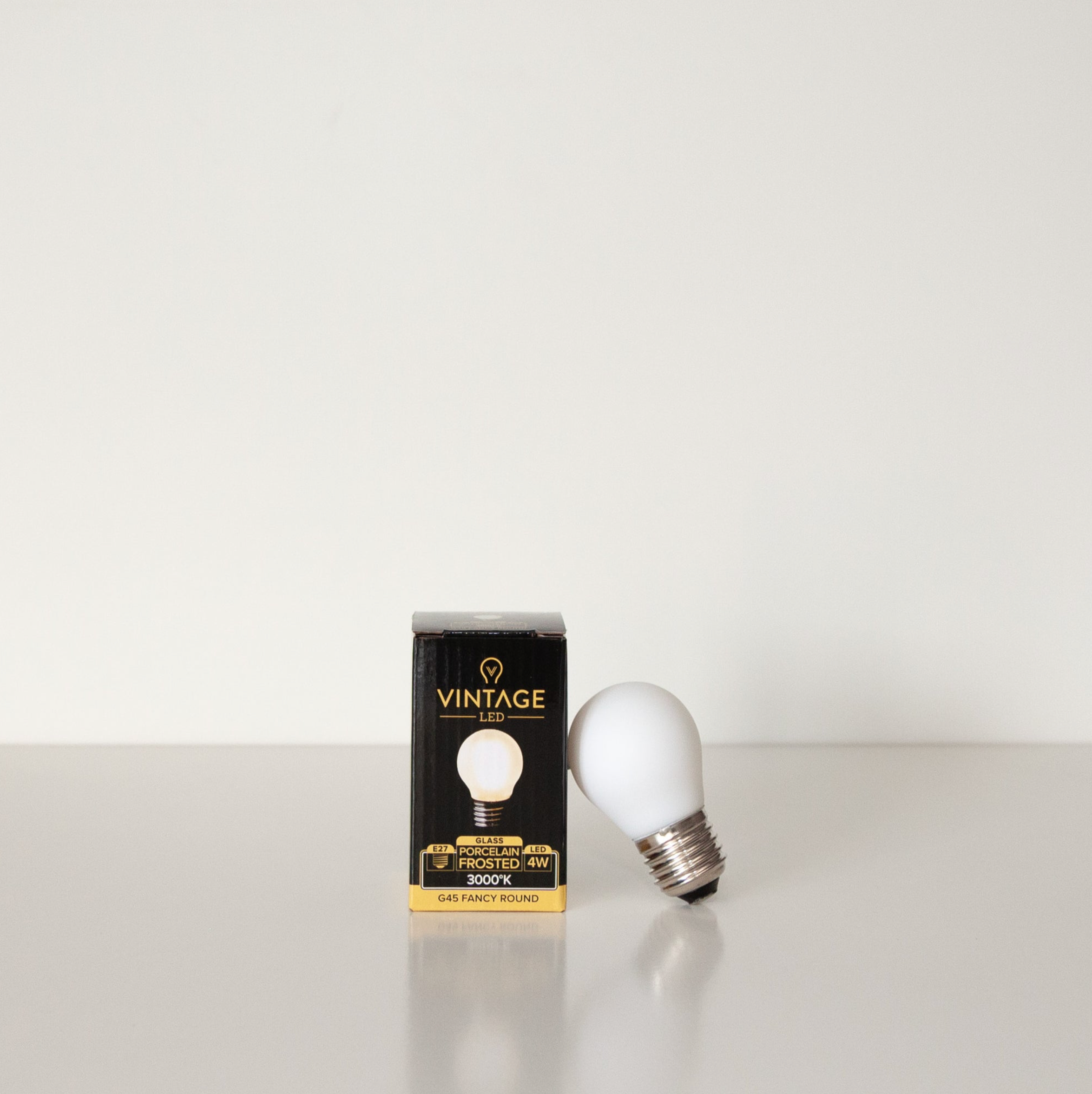 Vintage LED light bulb and its packaging on a white background