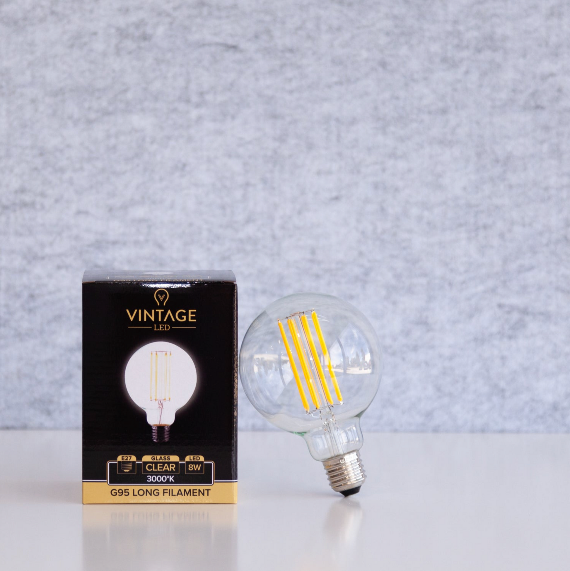 Vintage LED light bulb and its packaging on a gray background