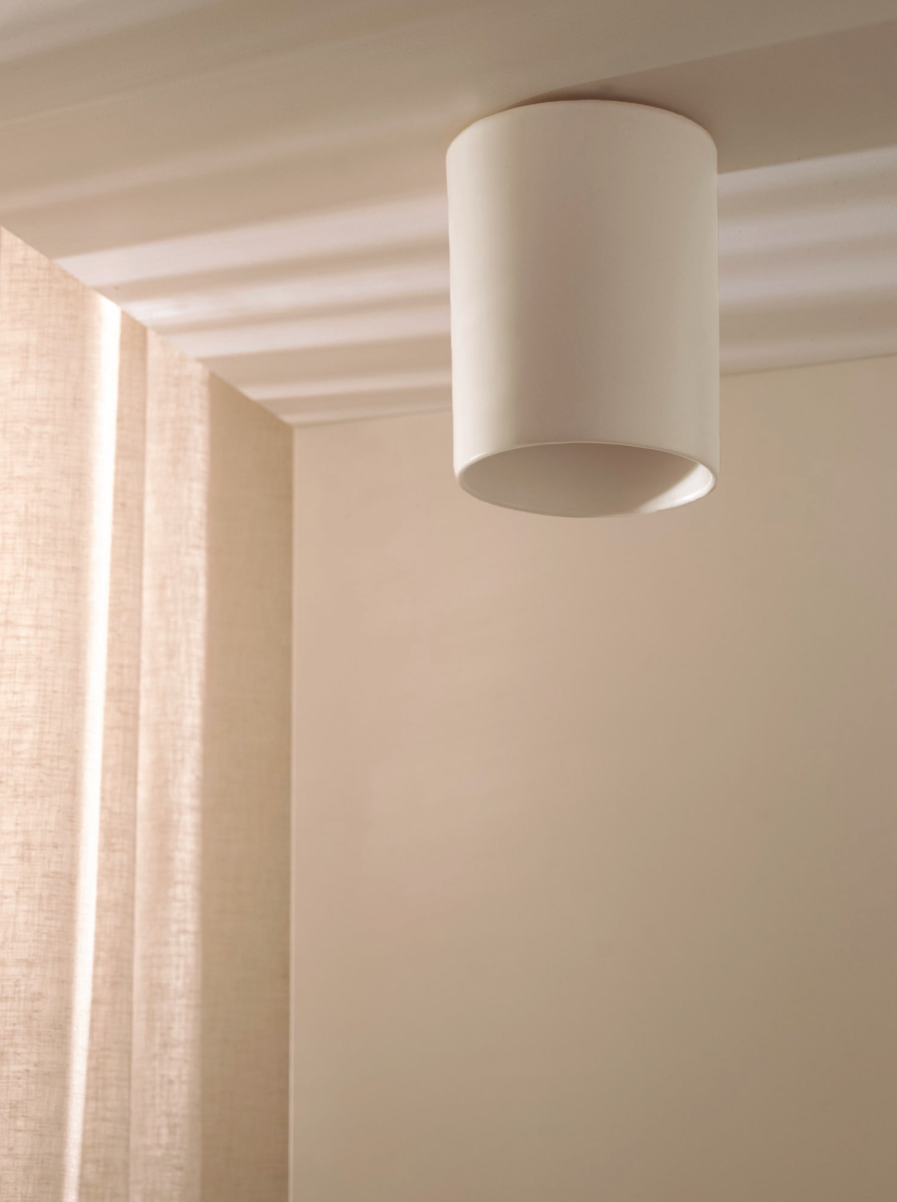 Ceiling light fixture in a room with curtains and neutral walls