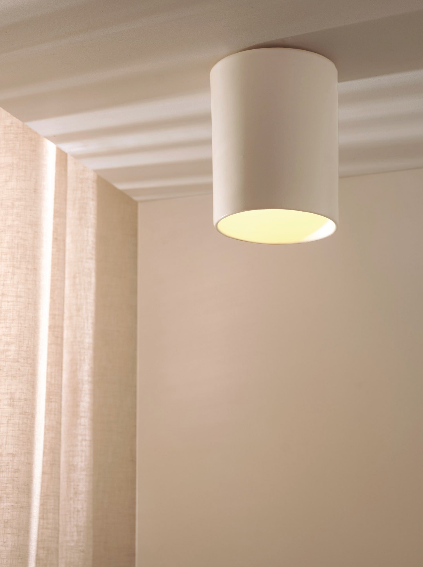 Ceiling light fixture in a room with curtains and neutral walls