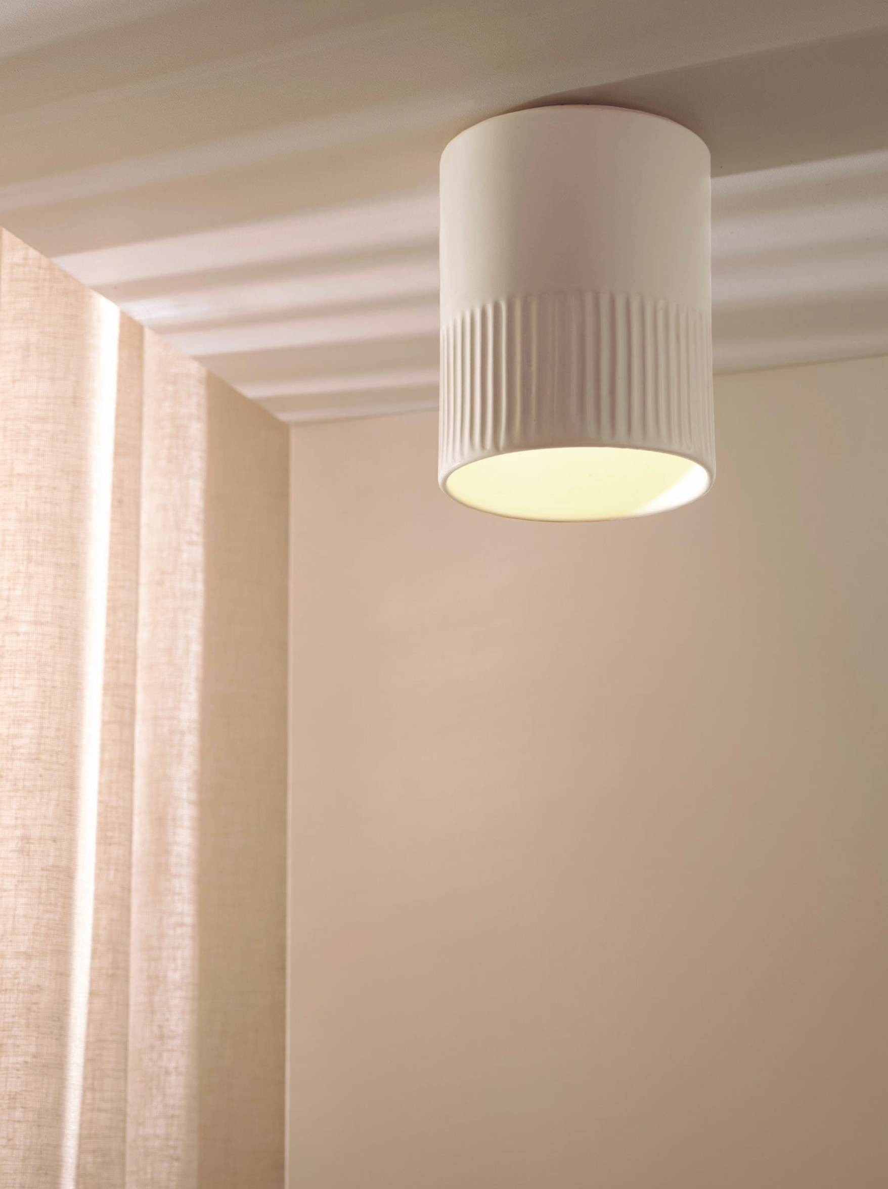Ceiling light fixture in a room with curtains and neutral walls