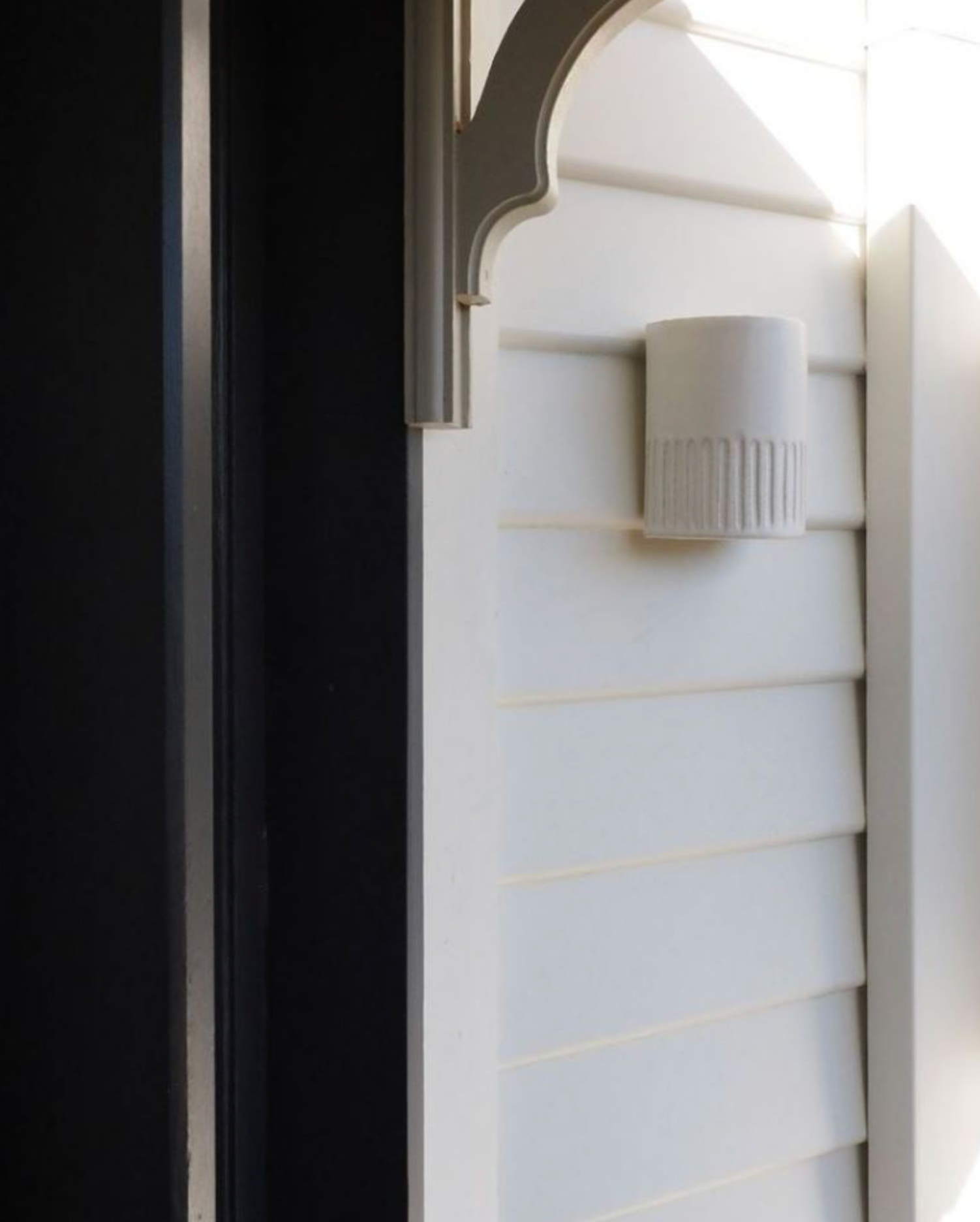 Close-up of a white radiator with a black wall in the background