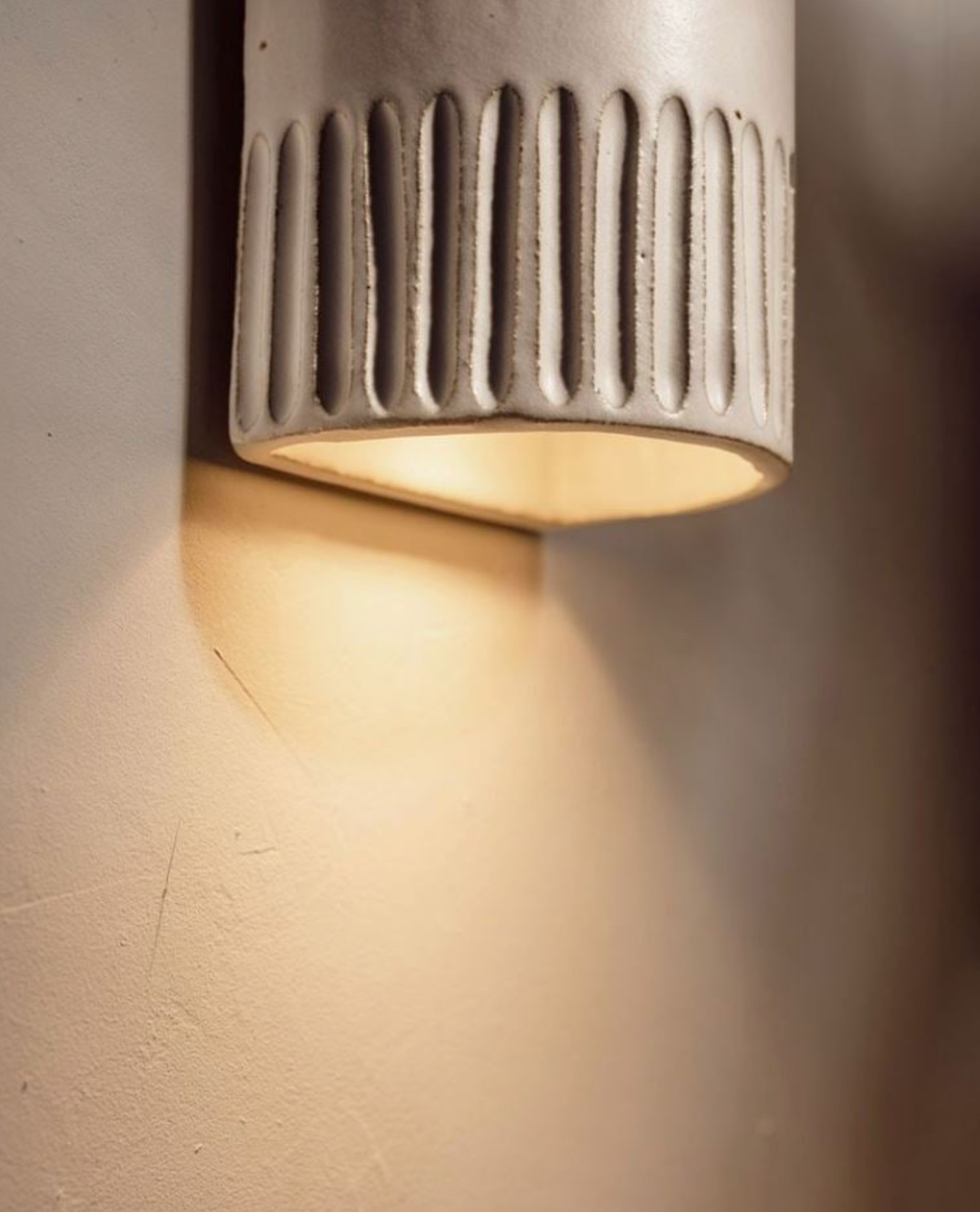 Ceramic textured outdoor wall light fixture on a neutral background