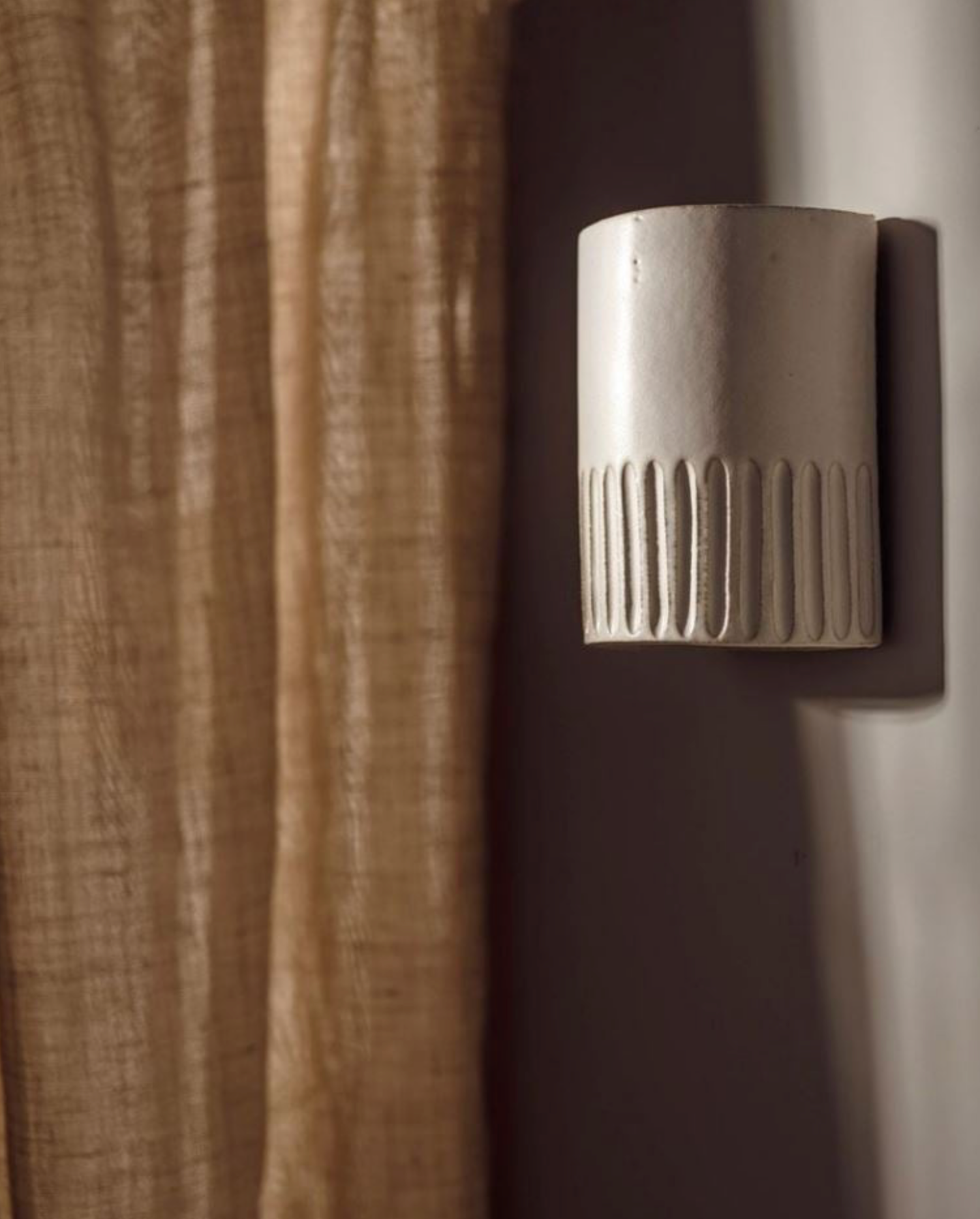 Textured wall sconce fixture on a neutral background