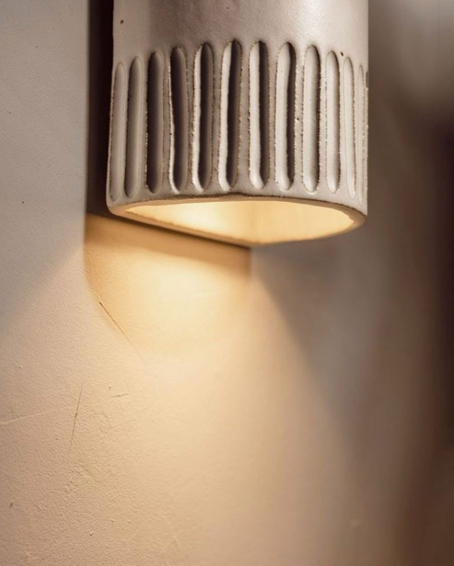 Ceramic light fixture on a wall with warm glow