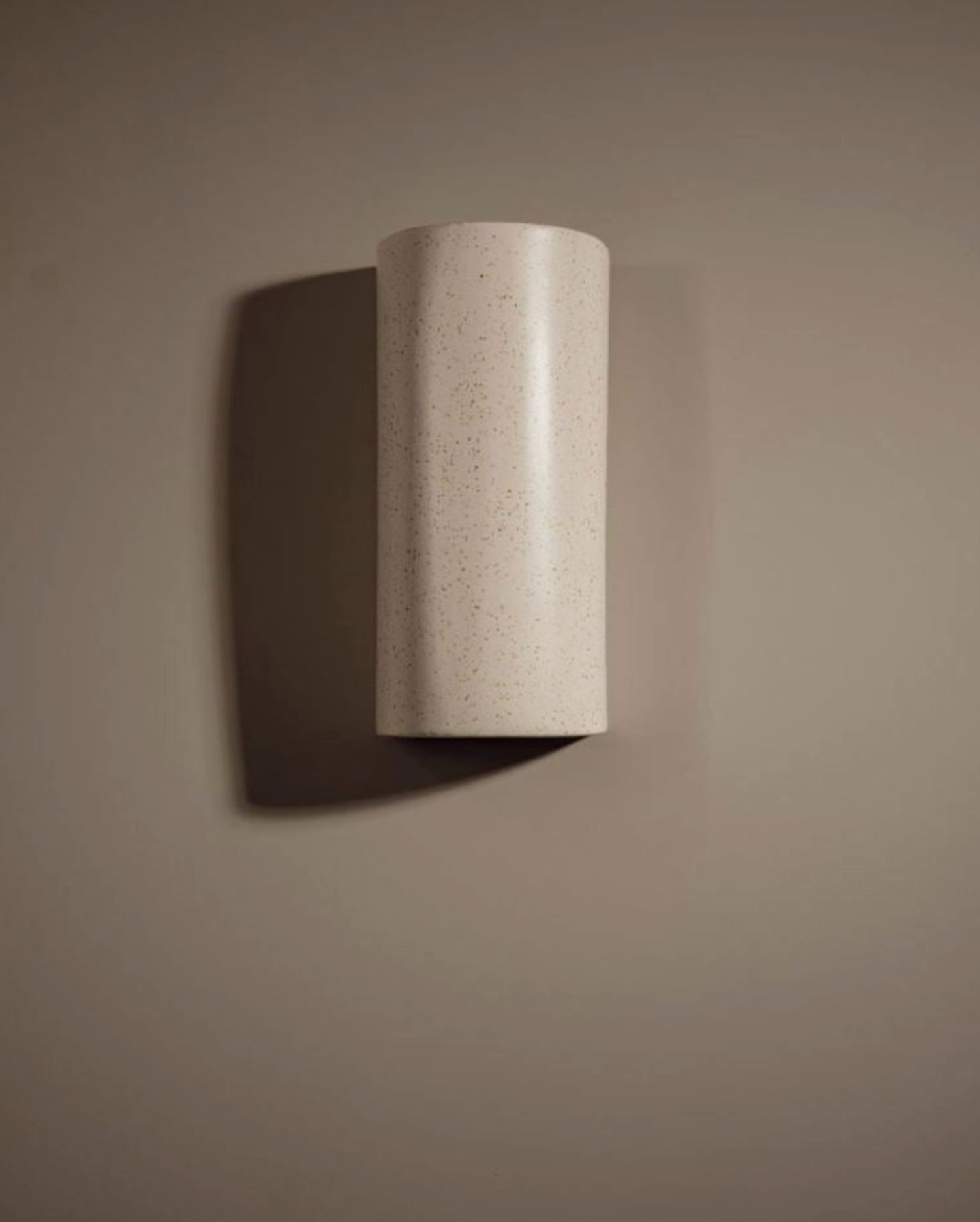 Cylindrical wall light fixture on a plain wall
