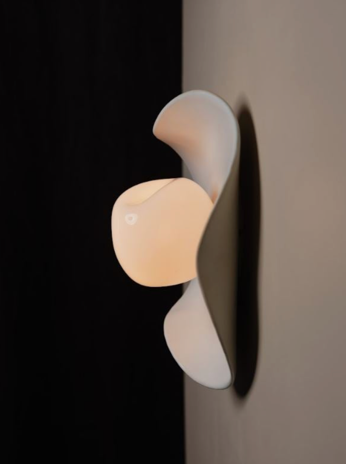 Modern wall lamp with a white and beige design on a dark background