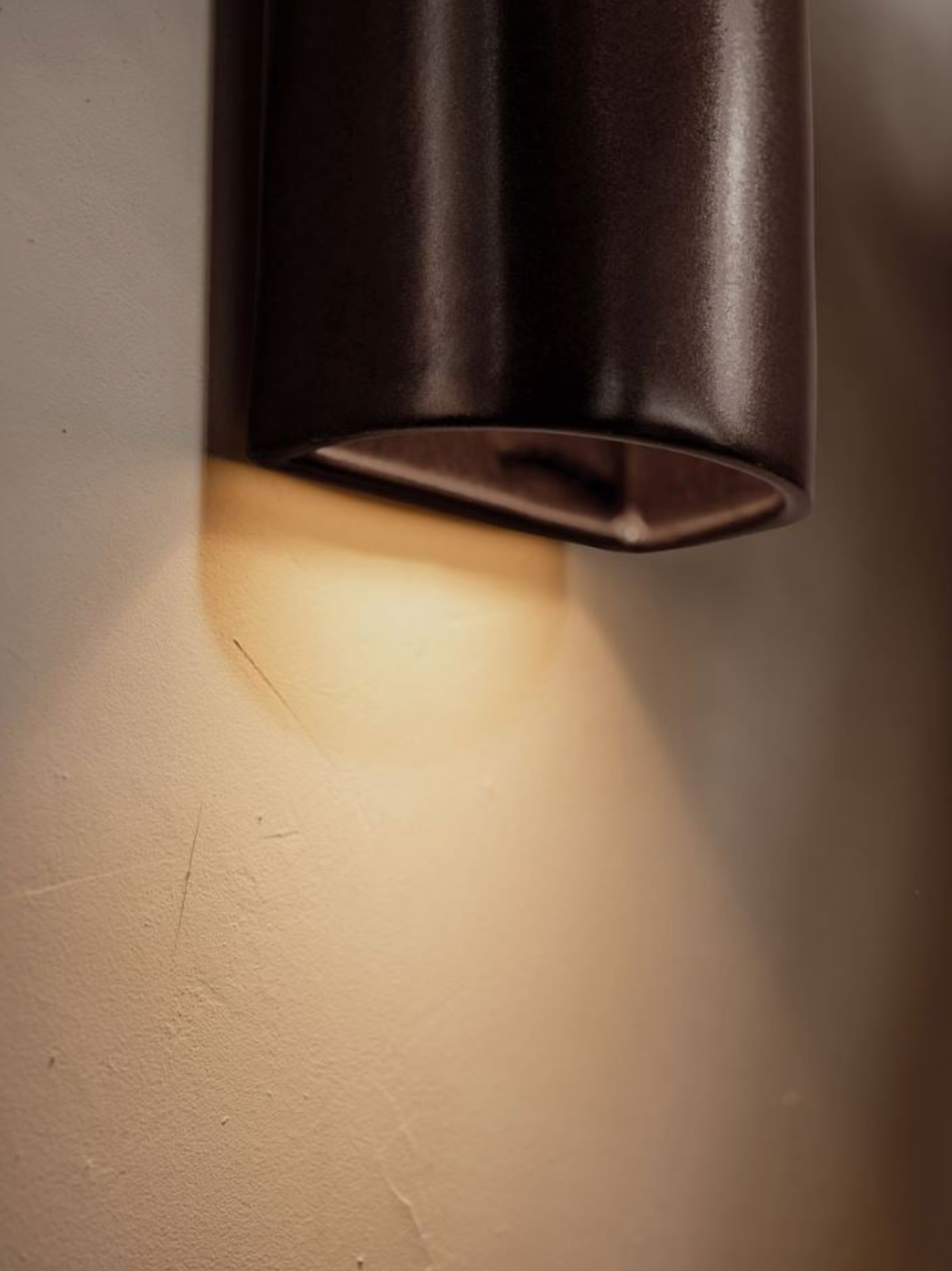 Indoor wall light fixture casting a warm glow on a wall.