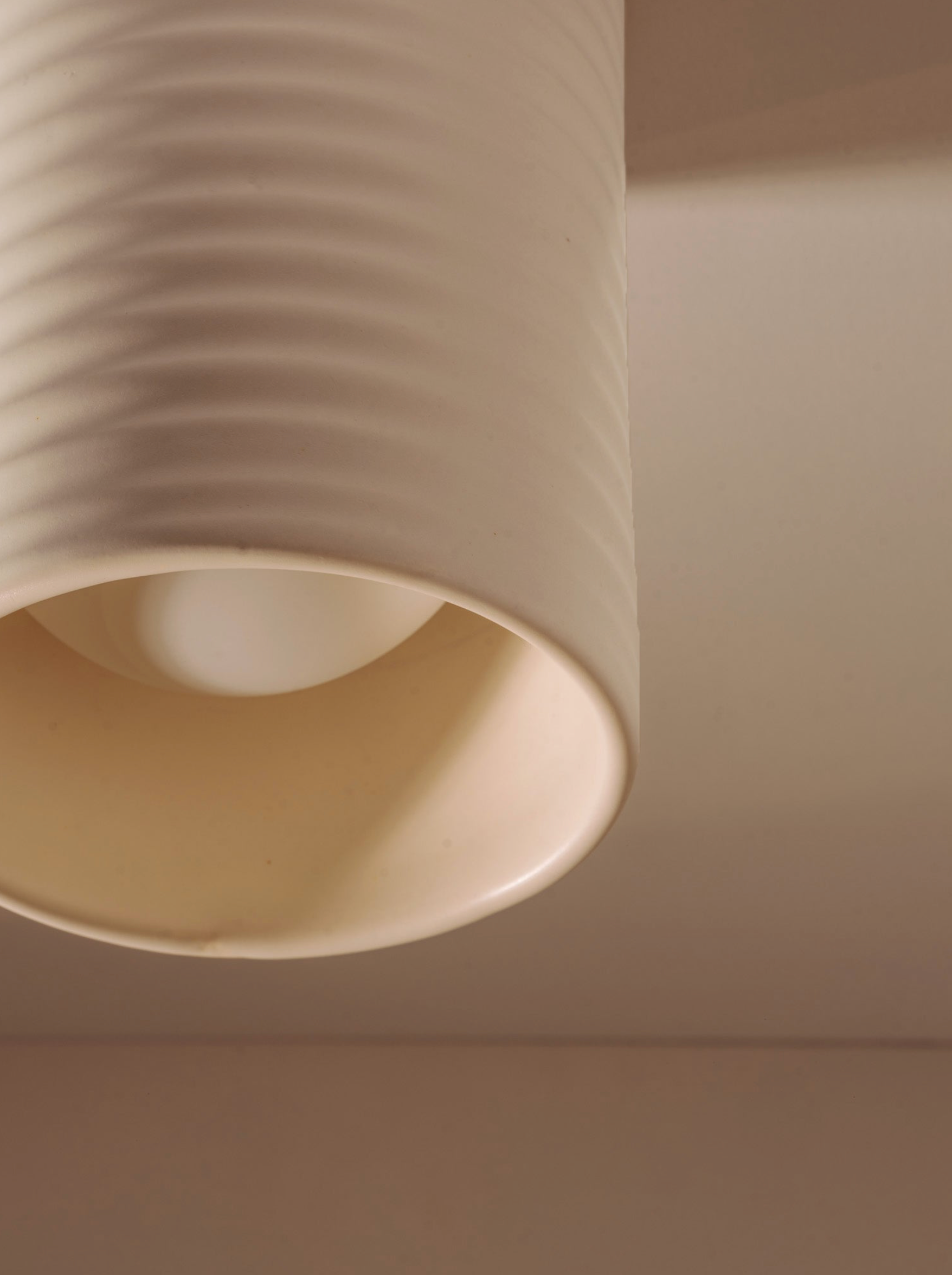 Close-up of a beige ceiling light fixture against a neutral background