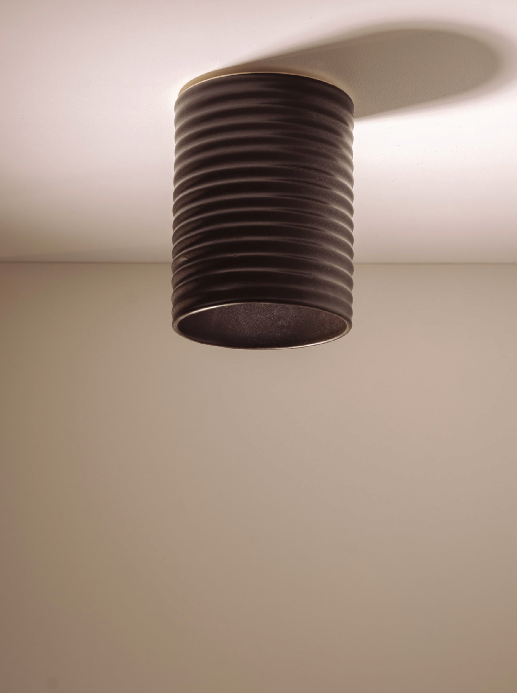 Ceiling light fixture with ribbed design on a plain ceiling