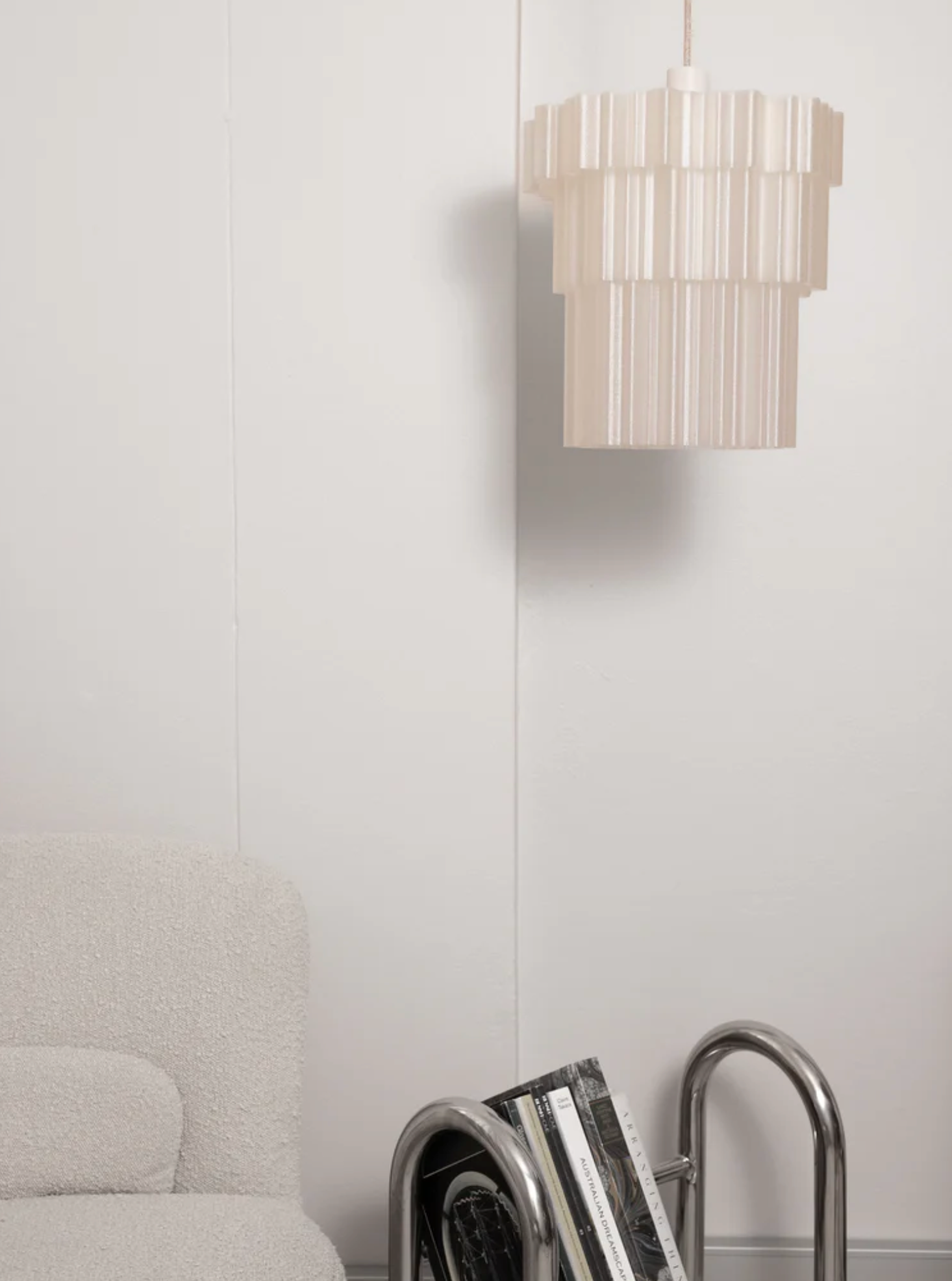 Delphine Pendant Light Pearl three-tiered 3D printed shade hanging above sofa against white wall – Franca Studio