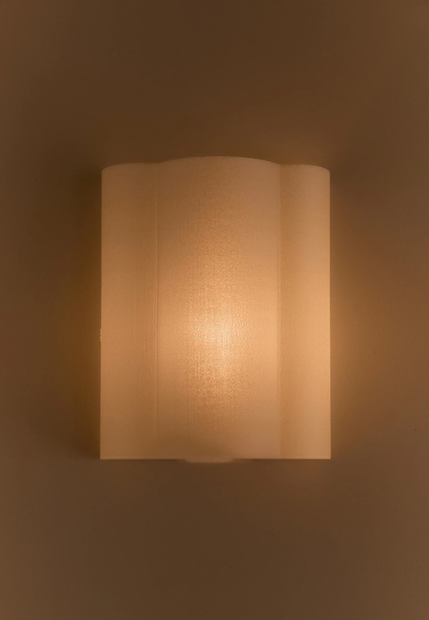 Eloise Wall Light Pearl 3D printed PLA shade illuminated with warm amber glow on dark wall – Franca Studio