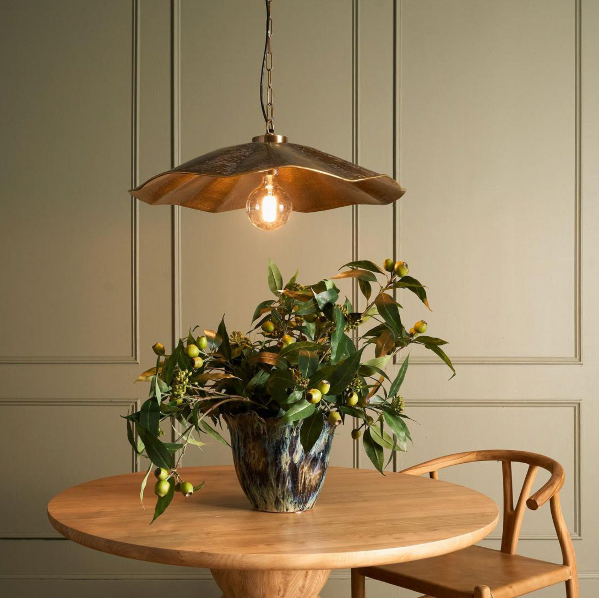 Melville Antique Brass Pendant Light above timber dining table with botanical arrangement – Lightingales