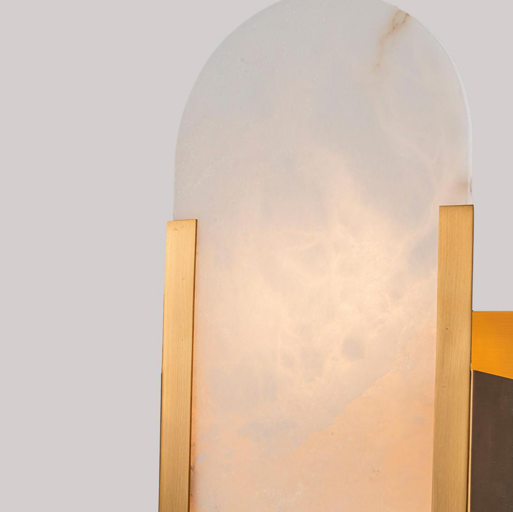 Close-up detail of Yves Wall Light antique brass frame alabaster stone shade glowing – Emac & Lawton