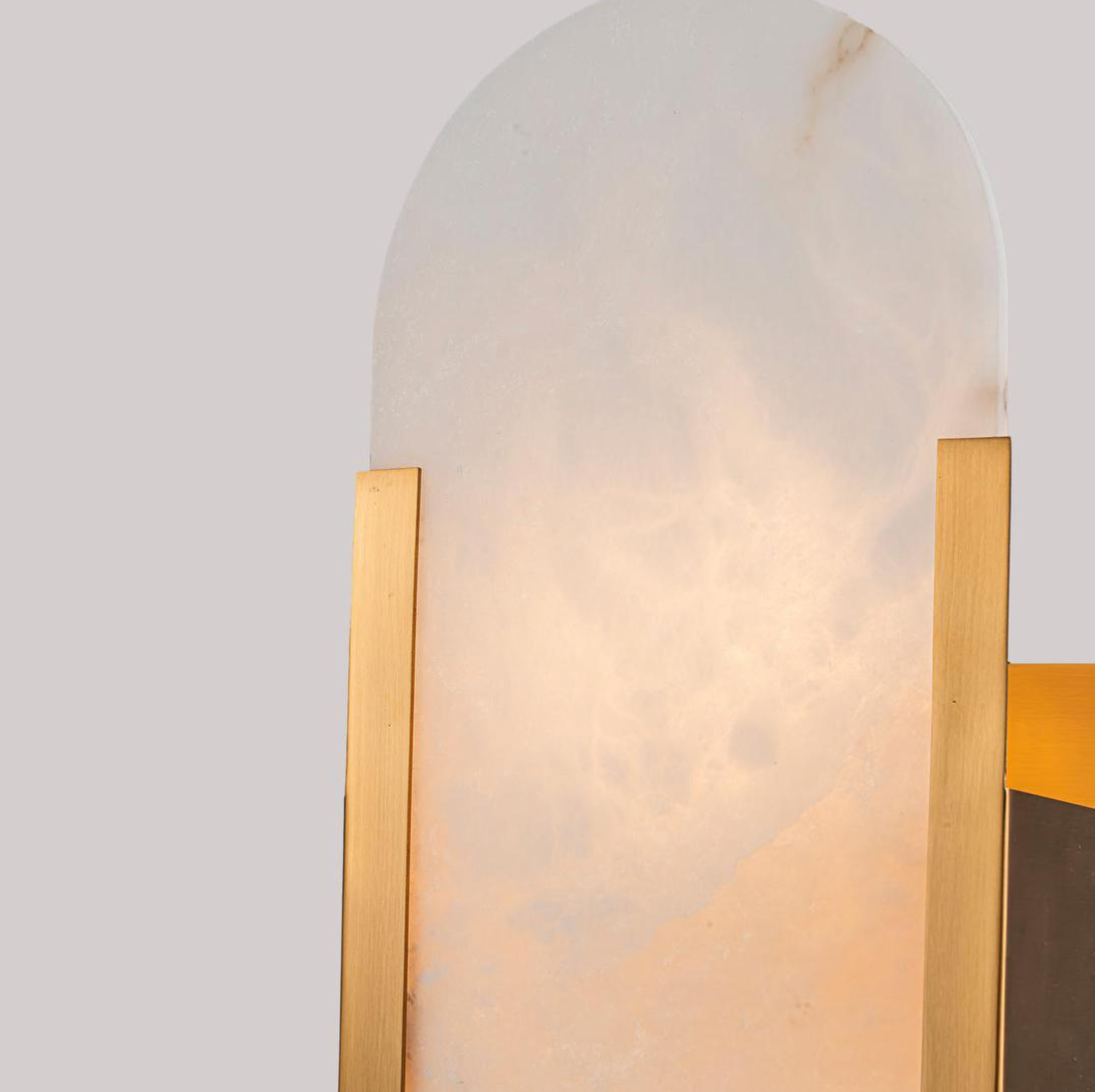 Close-up detail of Yves Wall Light antique brass frame alabaster stone shade glowing – Emac & Lawton