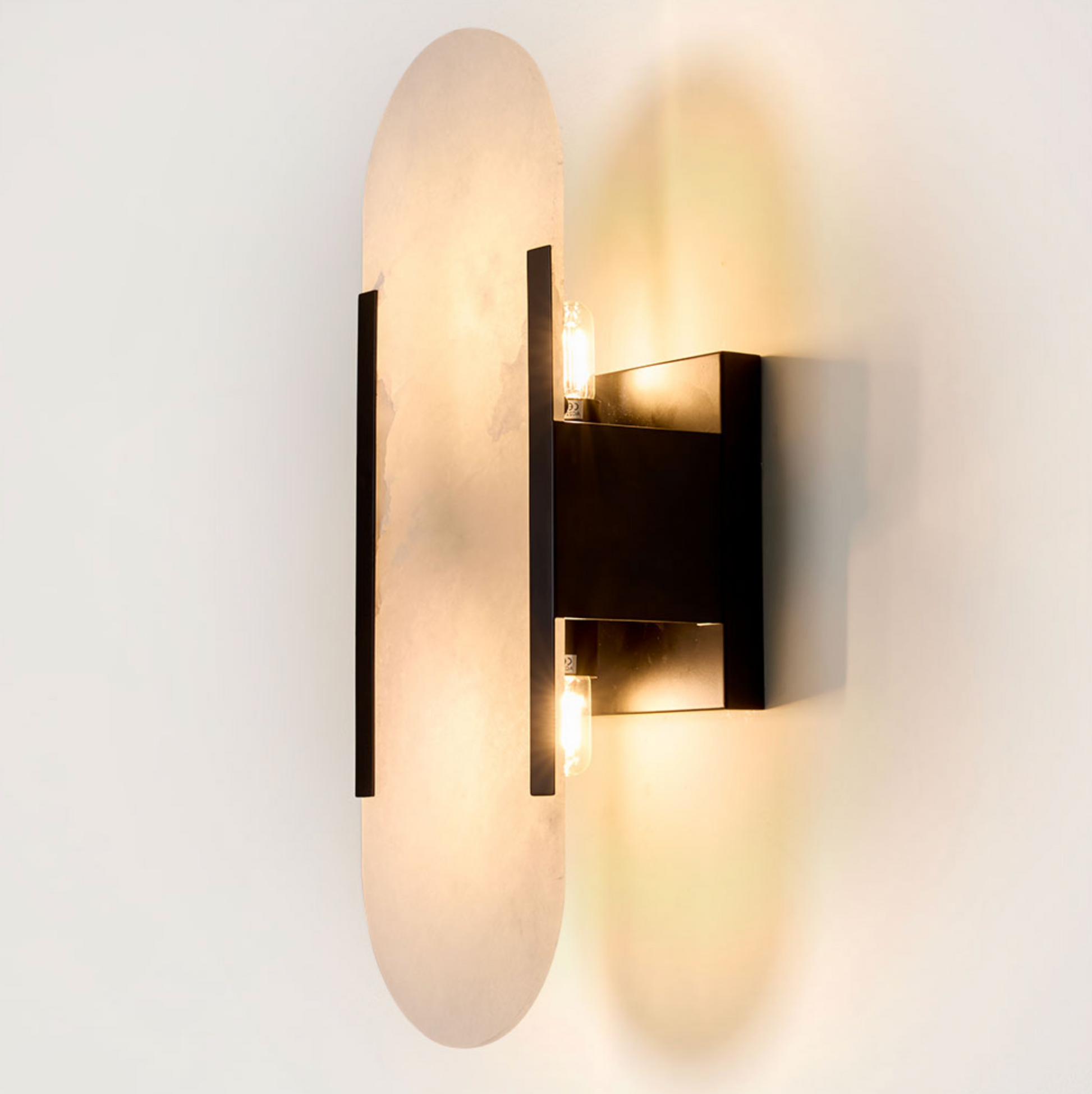 Yves Wall Light black frame alabaster shade illuminated close-up product shot – Emac & Lawton