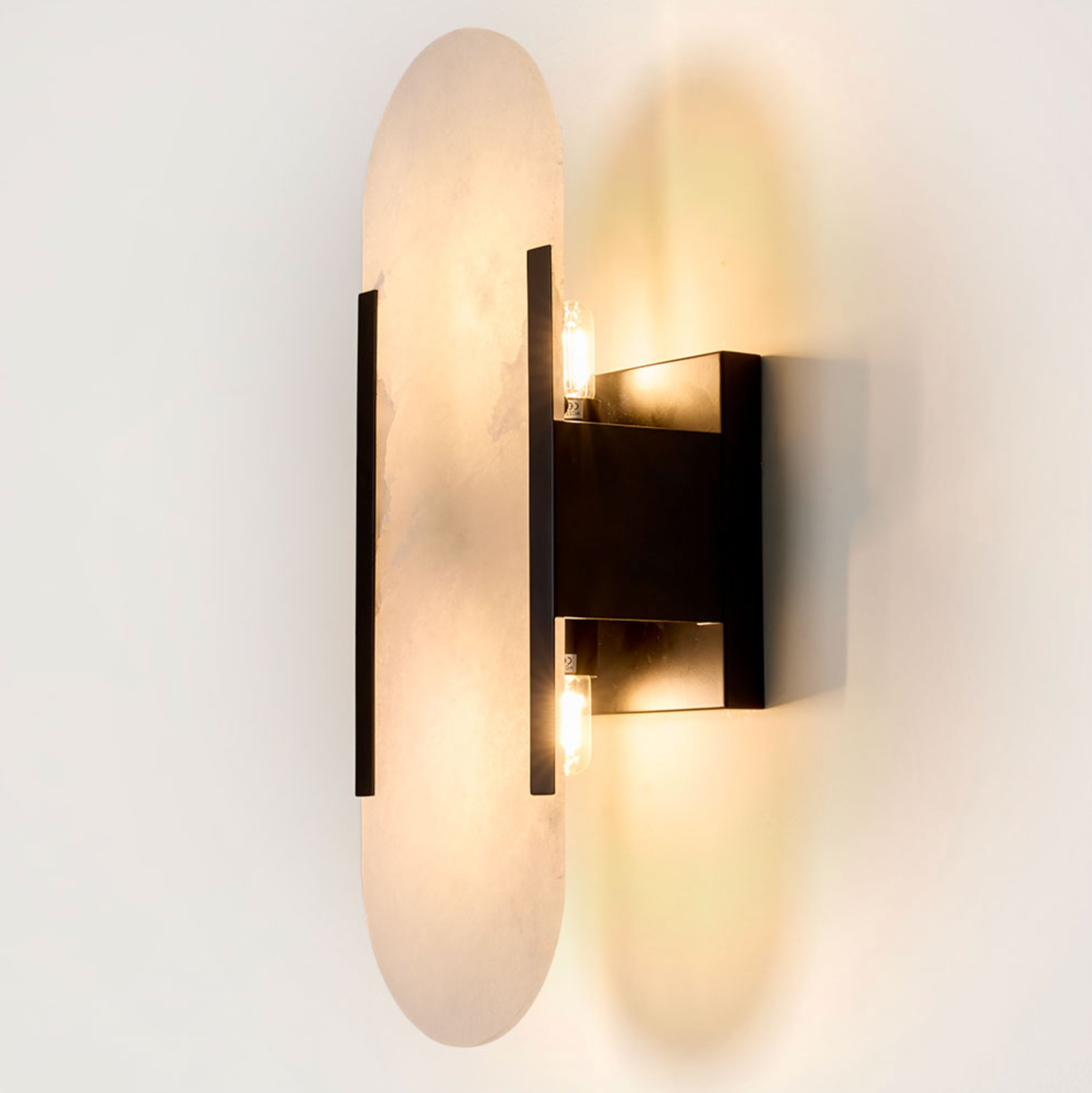 Yves Wall Light black frame alabaster shade illuminated close-up product shot – Emac & Lawton