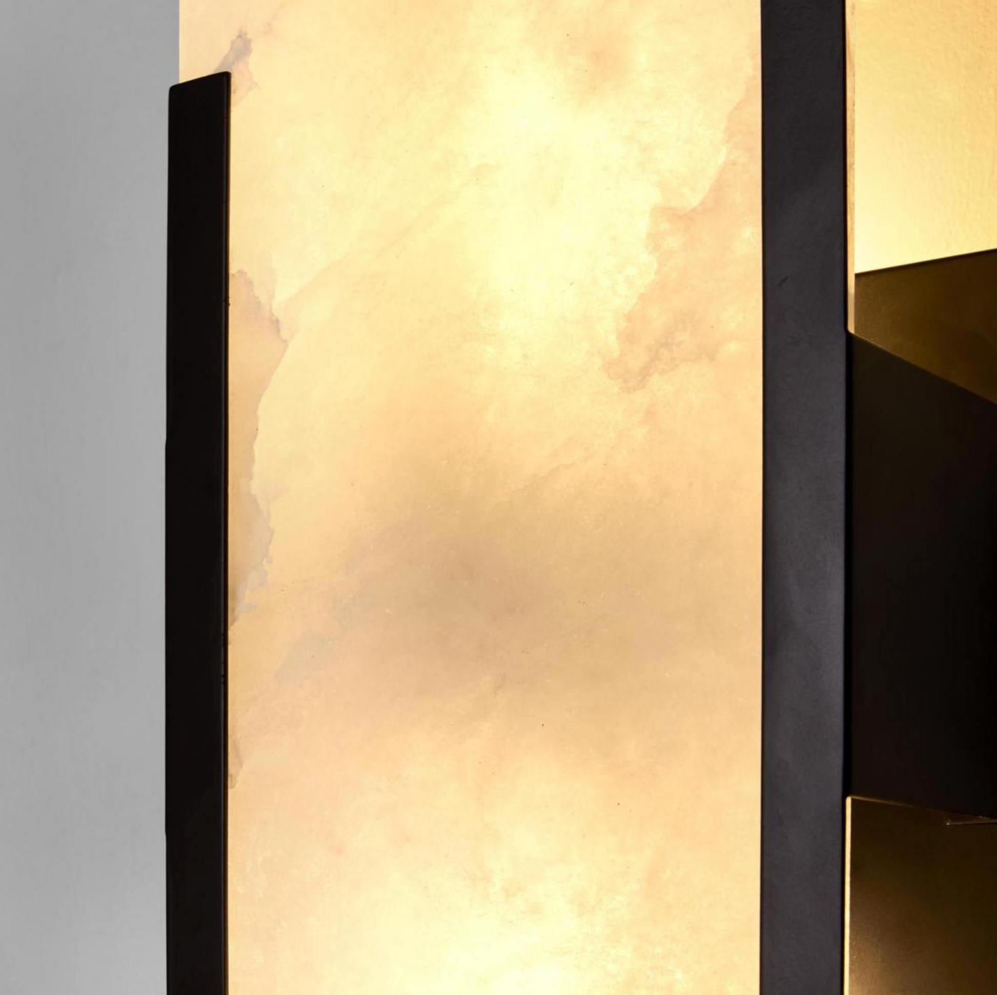 Close-up detail of Yves Wall Light black frame alabaster stone shade warm glow texture – Lightingales