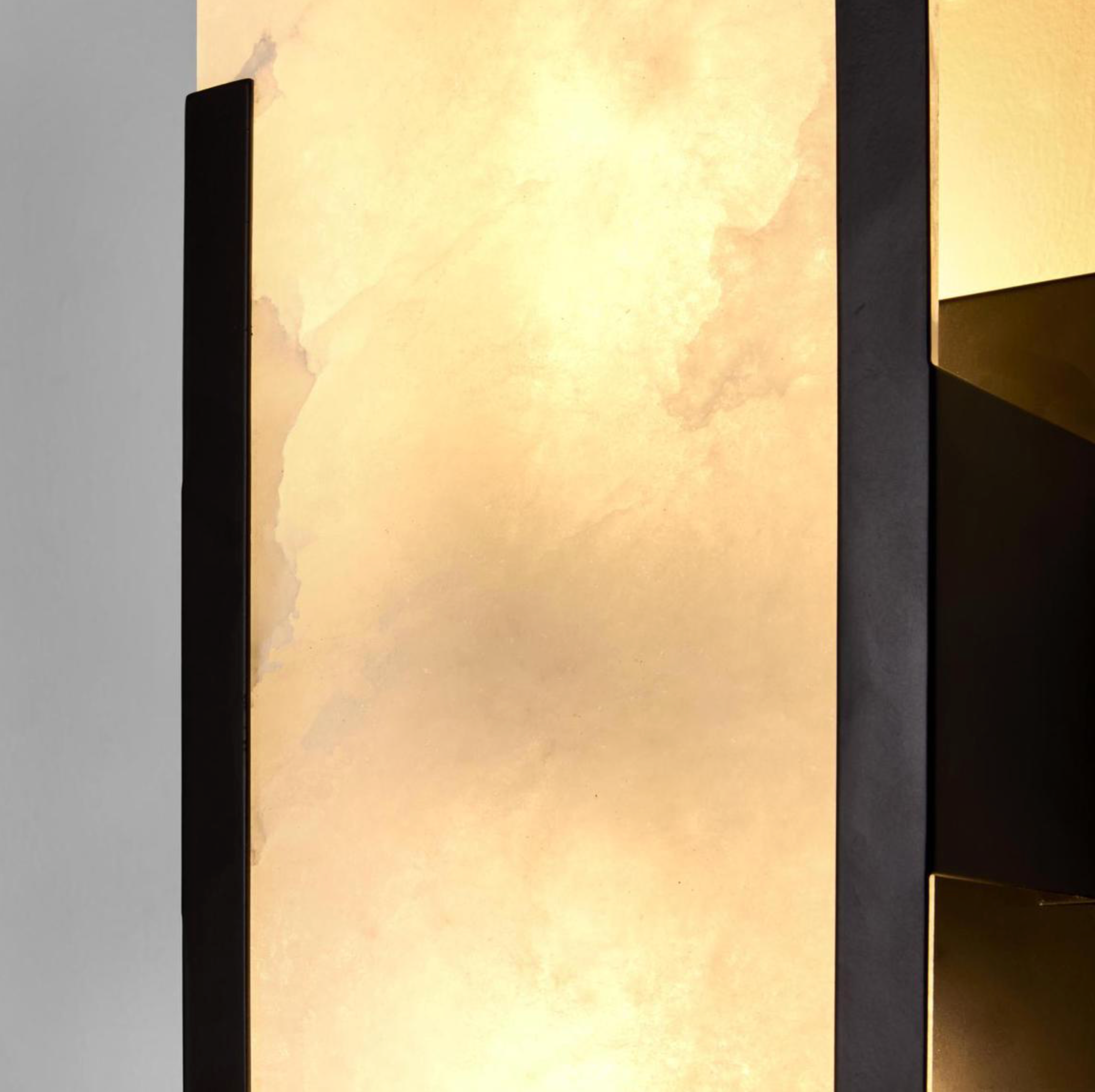 Close-up detail of Yves Wall Light black frame alabaster stone shade warm glow texture – Lightingales